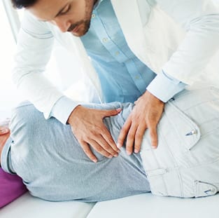 chiropractor checking old man back pain problem