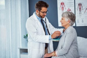 A Doctor checking Heart beat of lady patient