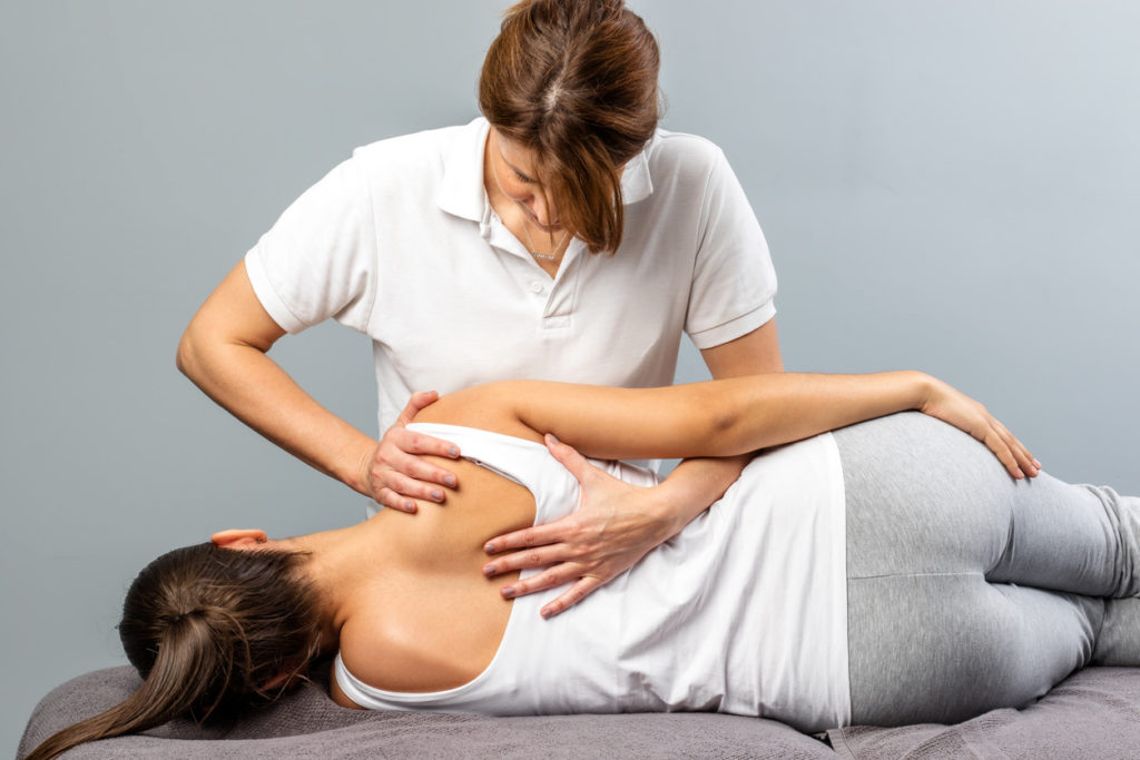 Female therapist manipulating shoulder