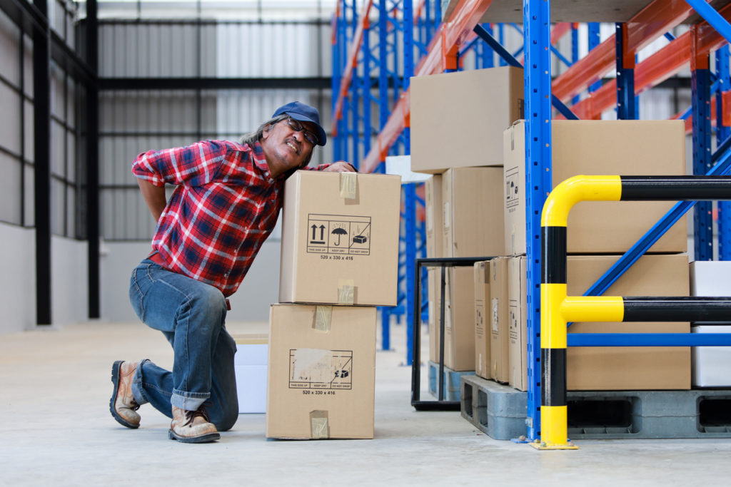 Asian worker man hurt his back "nlift heavy box in factory