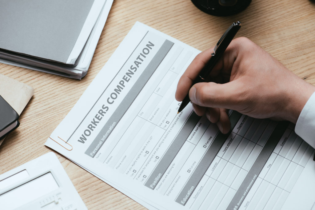man filling in Workers Compensation Accident Injury Concept