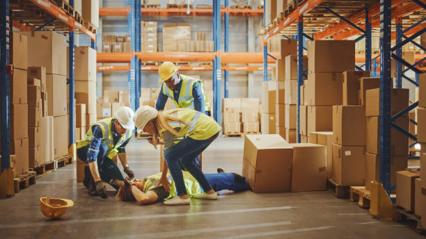 Warehouse Worker Has Work Related Accident Falls while Trying to Pick Up Box and co-workers helping him