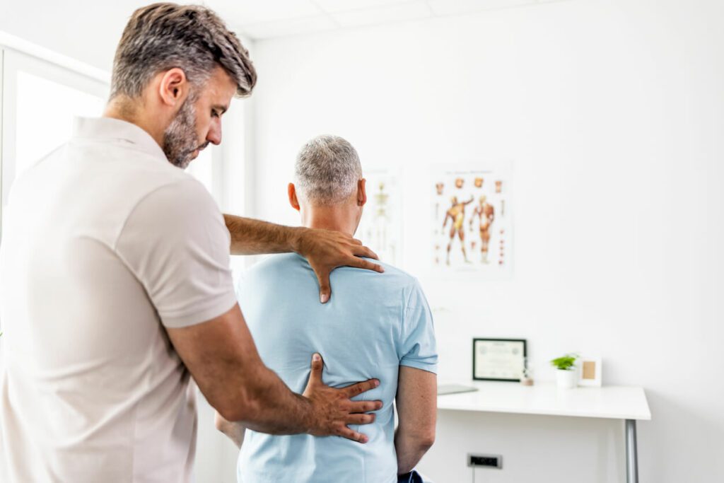 Mature man having chiropractic back adjustment