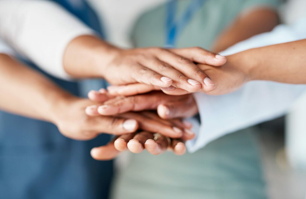 An image depicting hands joined together to symbolize a business's support for employees' health.