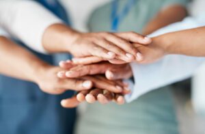 An image depicting hands joined together to symbolize a business's support for employees' health.