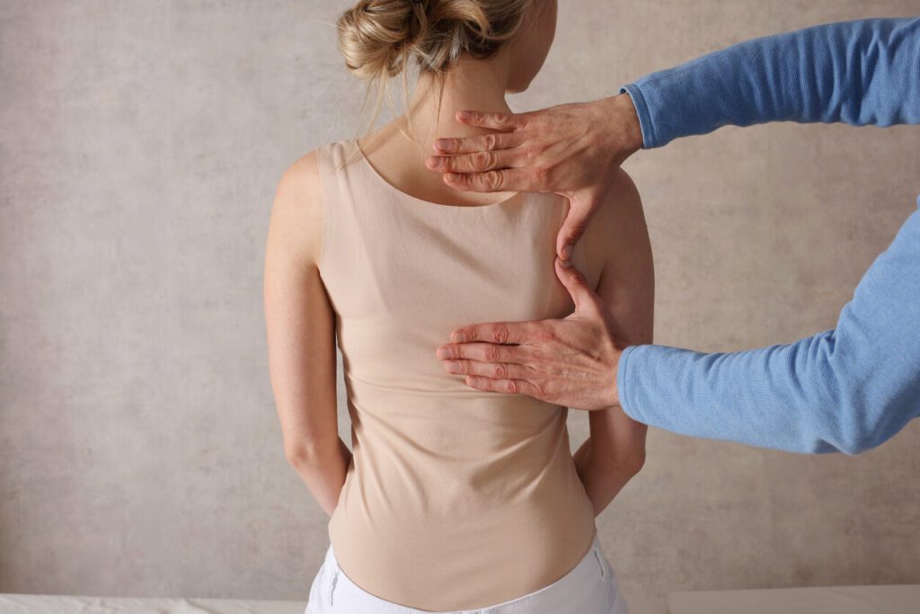 A woman receiving chiropractic back adjustments and physiotherapy treatment for her spine health.
