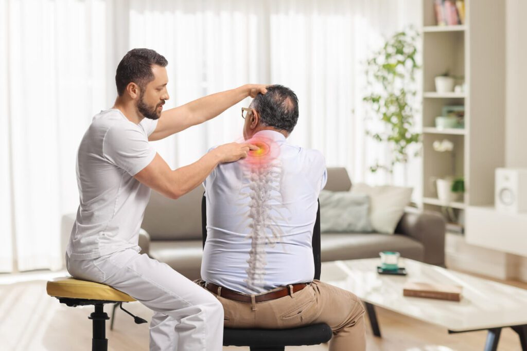 A chiropractor providing a massage to a senior worker who has sustained a work injury.