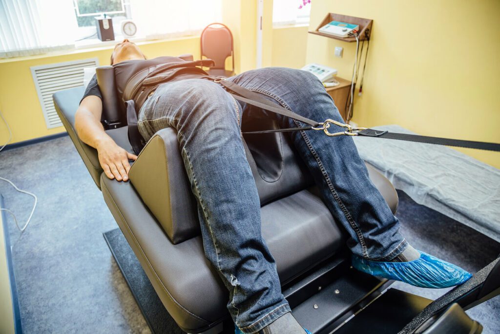 A man receiving non-surgical spinal decompression therapy as part of his physical therapy for spine health.