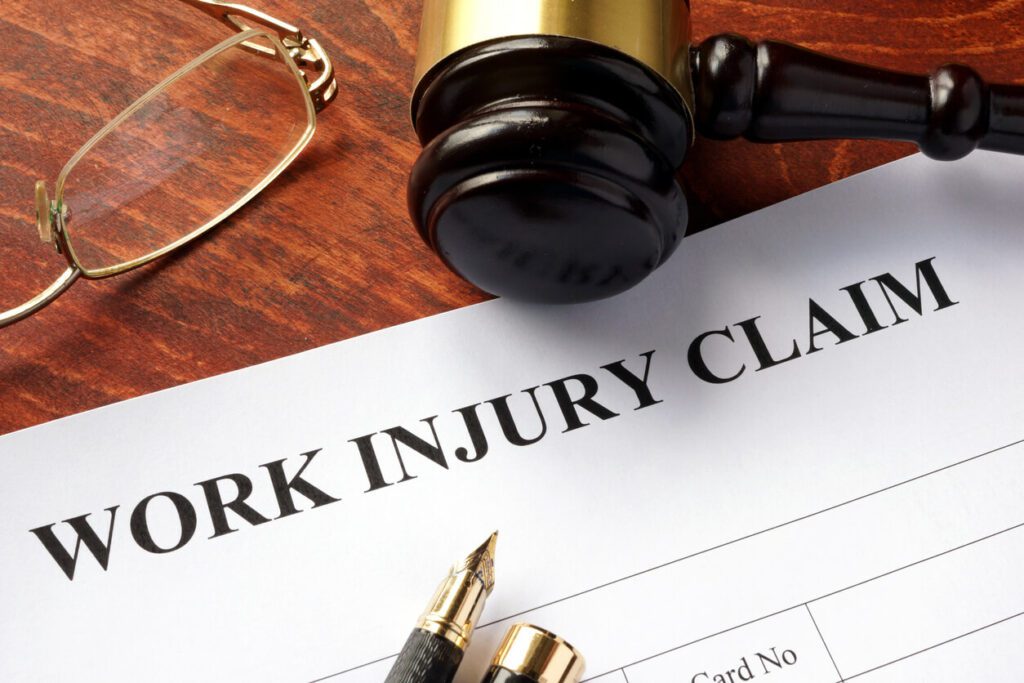 The worker compensation law concept, where the work injury claim document is on a table.