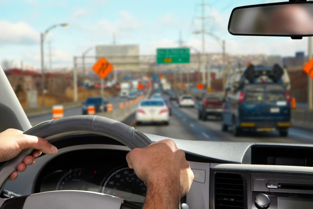 Image of a car on the highway with a driver after a DOT physical.