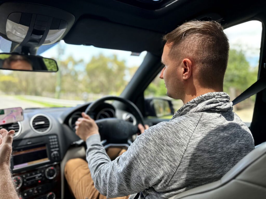 Portrait of man driving car for DOT Physicals.